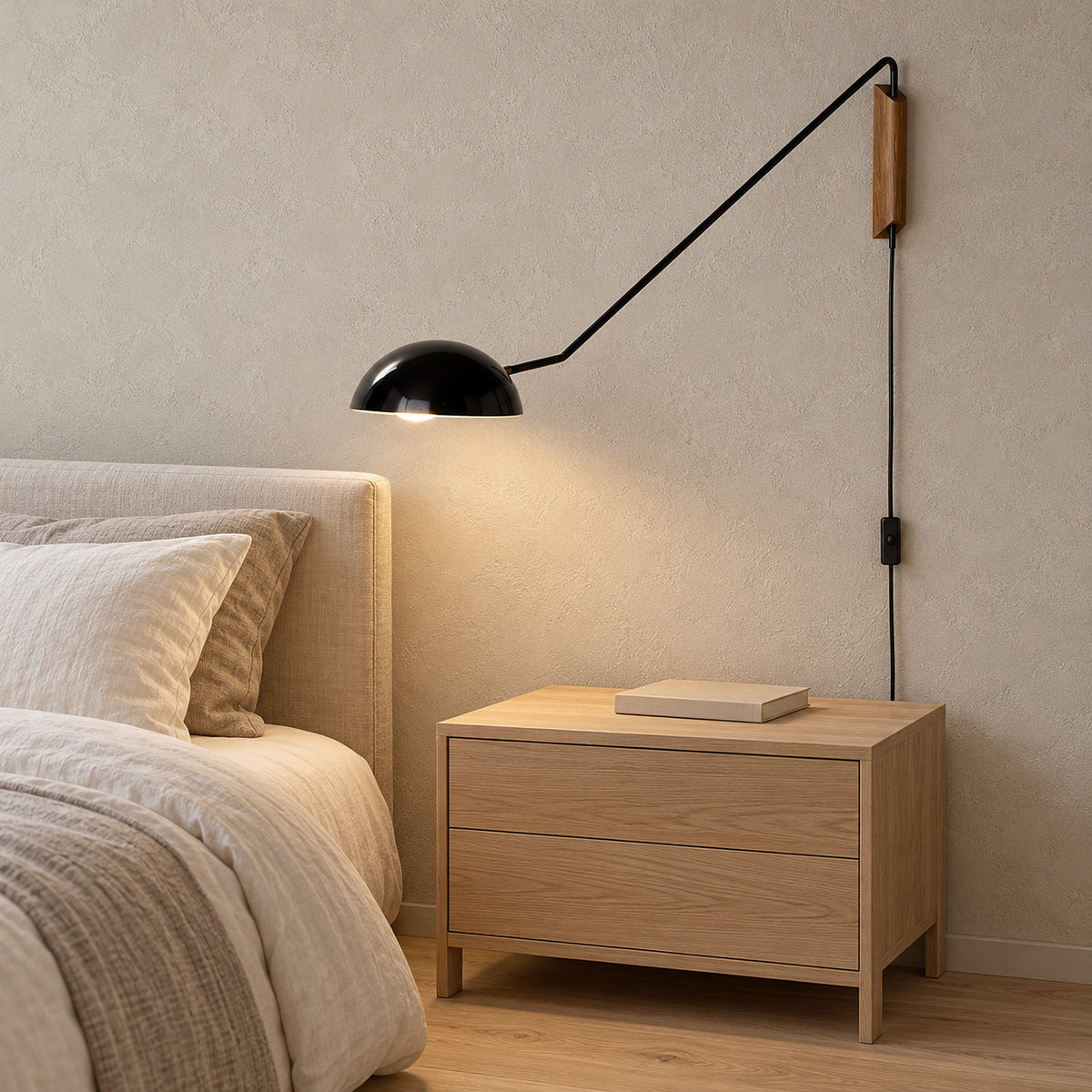 Nalesio black plug in wall lamp mounted base and power cord visible beside a guest bed