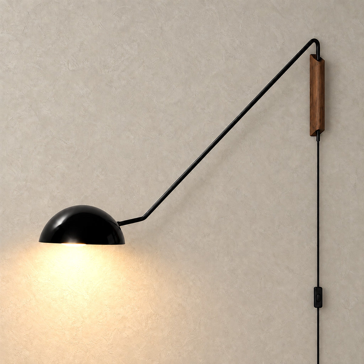 Nalesio black plug in wall sconce glowing with warm light beneath its metal dome shade
