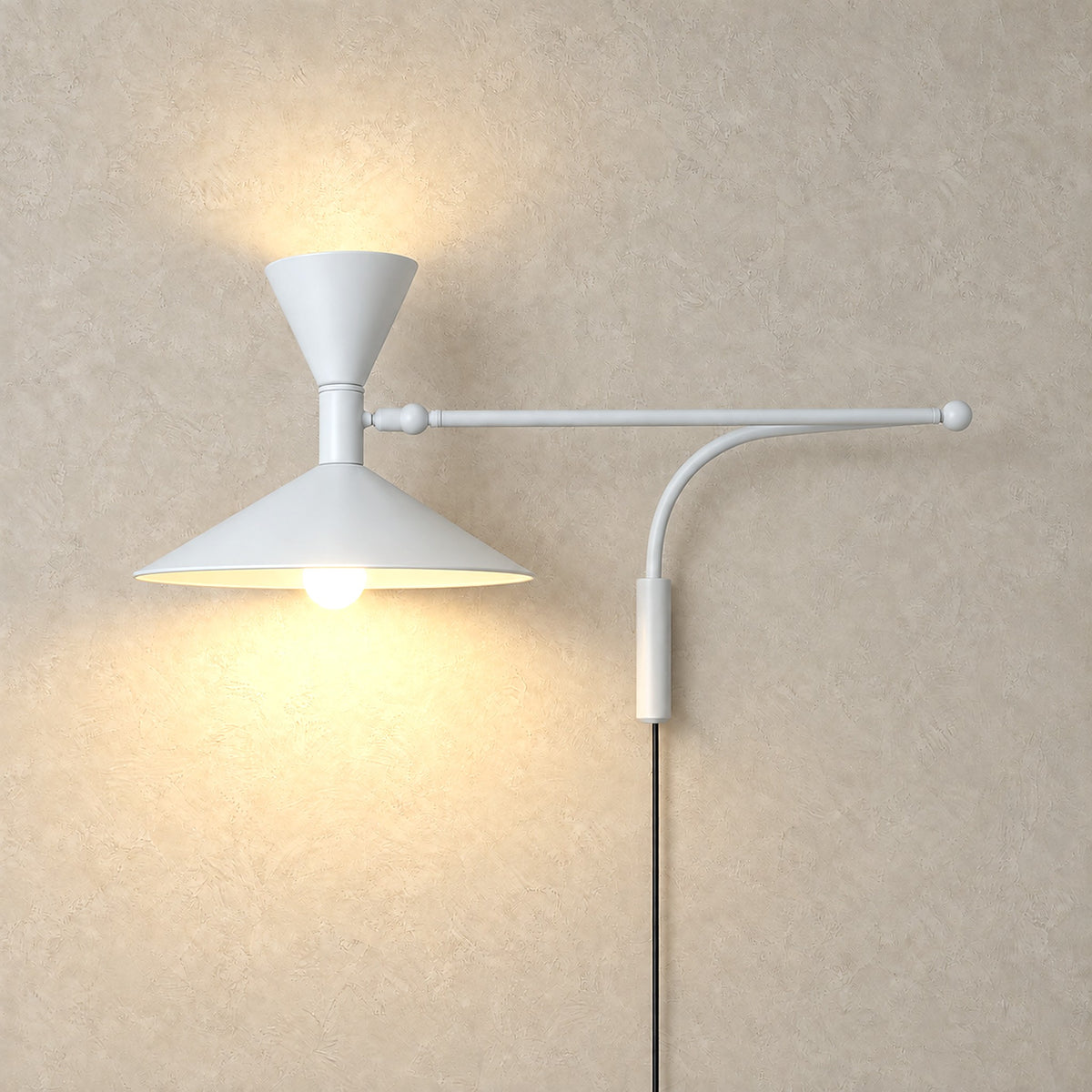 Nalveto white double cone wall light glowing above and below on a plain backdrop