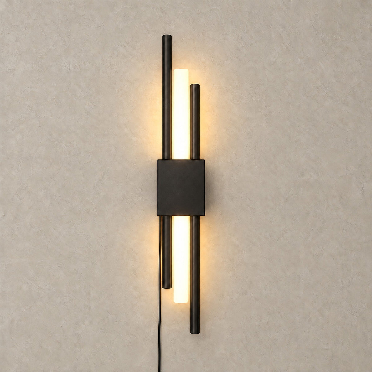 Nemirsa black LED wall sconce switched on, its tubular sections giving a warm glow