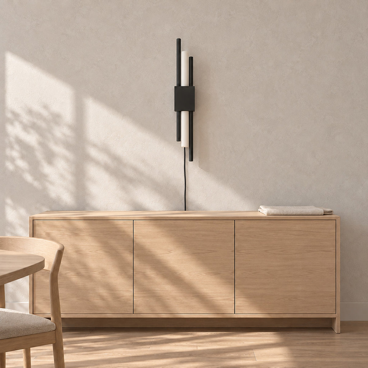 Nemirsa black plug in wall lamp switched off, its staggered rods reading as wall art in a dining room