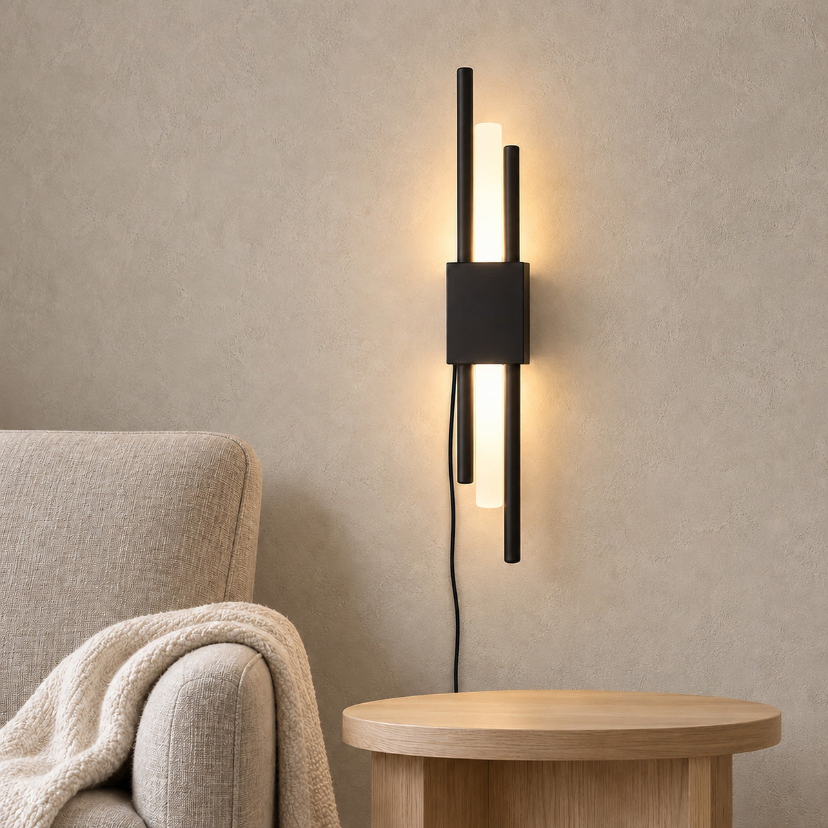 Nemirsa black wall lamp glowing above an empty side table in a daytime armchair reading alcove