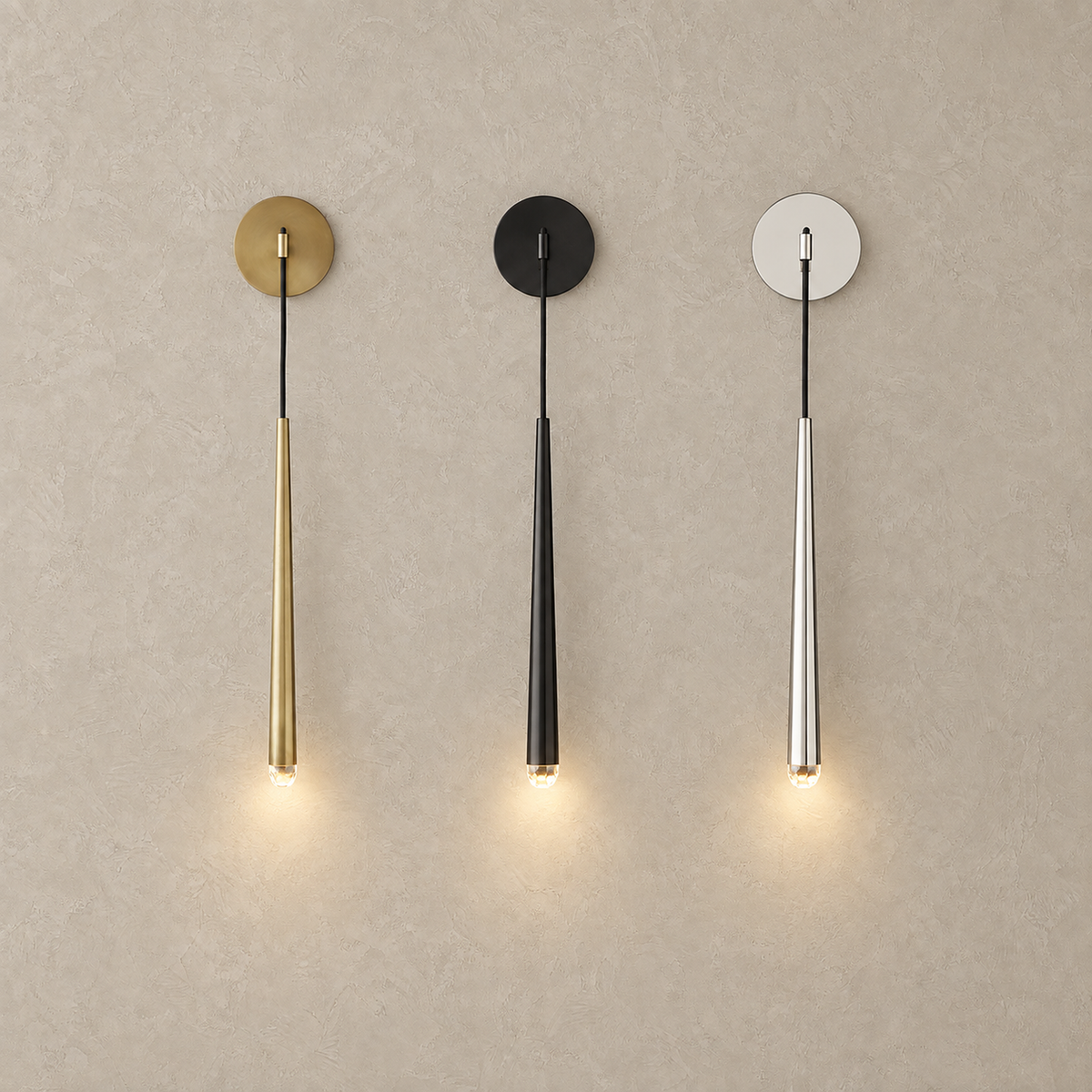 Nerisavo wall sconce lit in polished brass, blackened and silver finishes on a plain backdrop