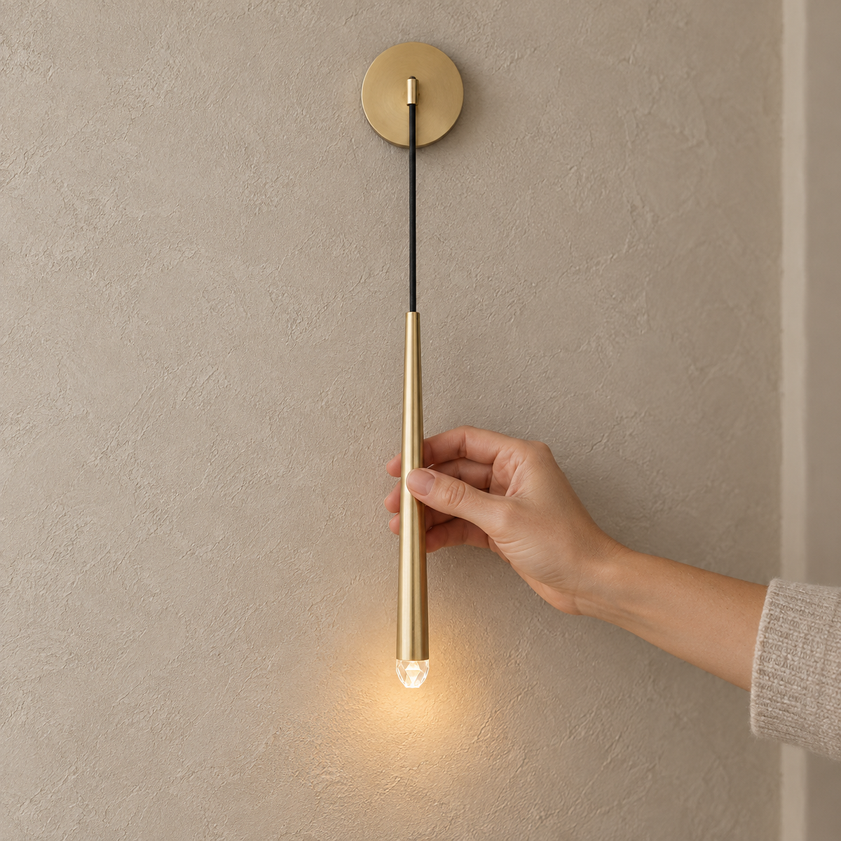 Nerisavo polished brass LED wall sconce lit in a hallway, cone hanging from one round wall plate