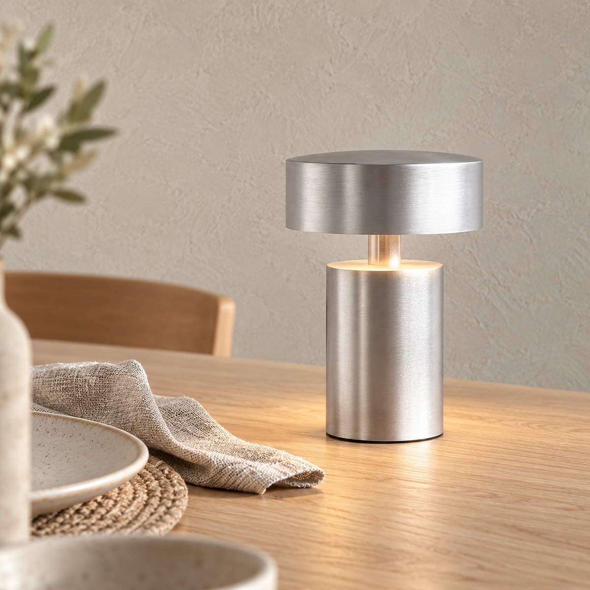 Nesarlo silver portable table lamp glowing in a dining nook during the day
