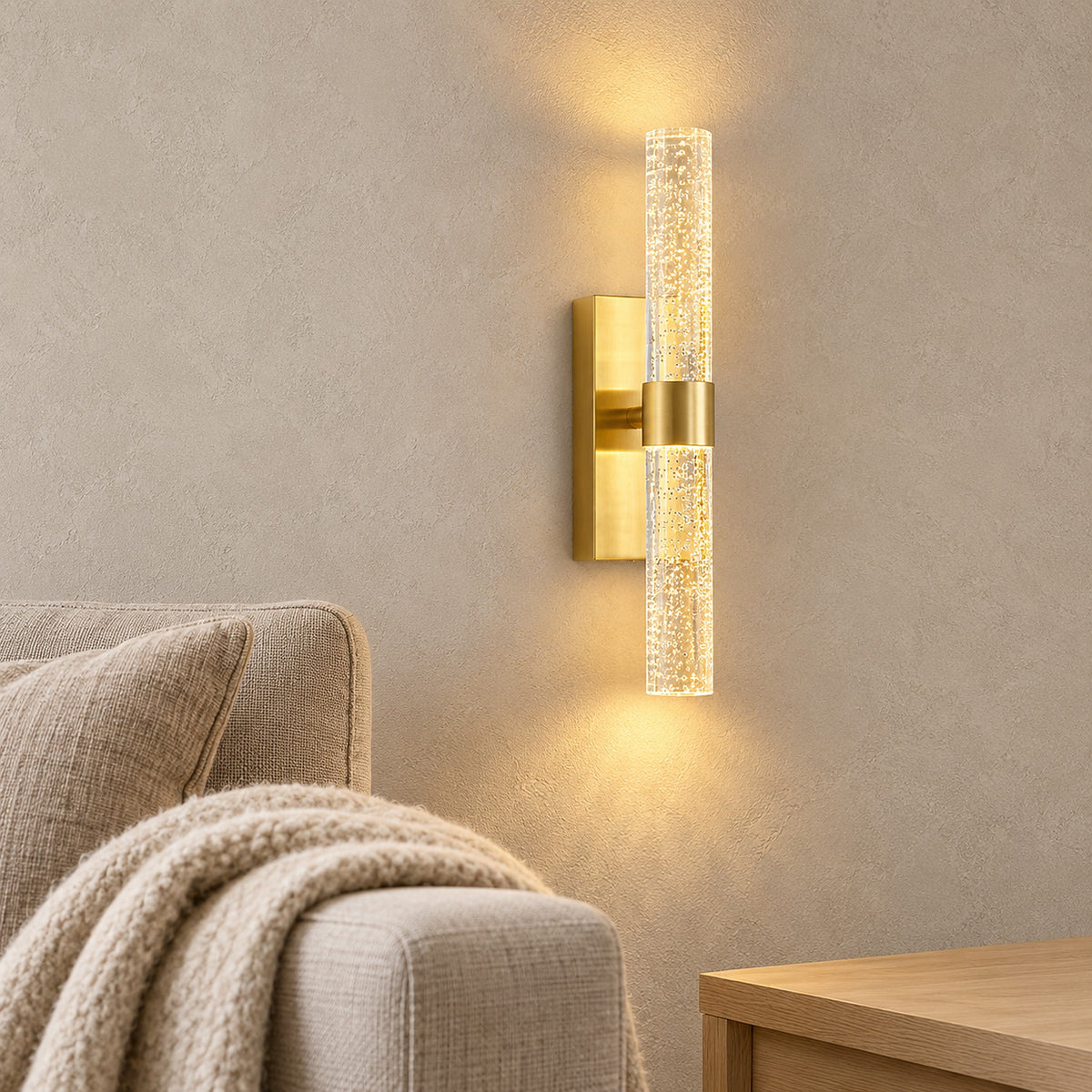 Nimarlo gold cordless wall lamp glowing beside a library sofa, lighting the room with no lamp on the table