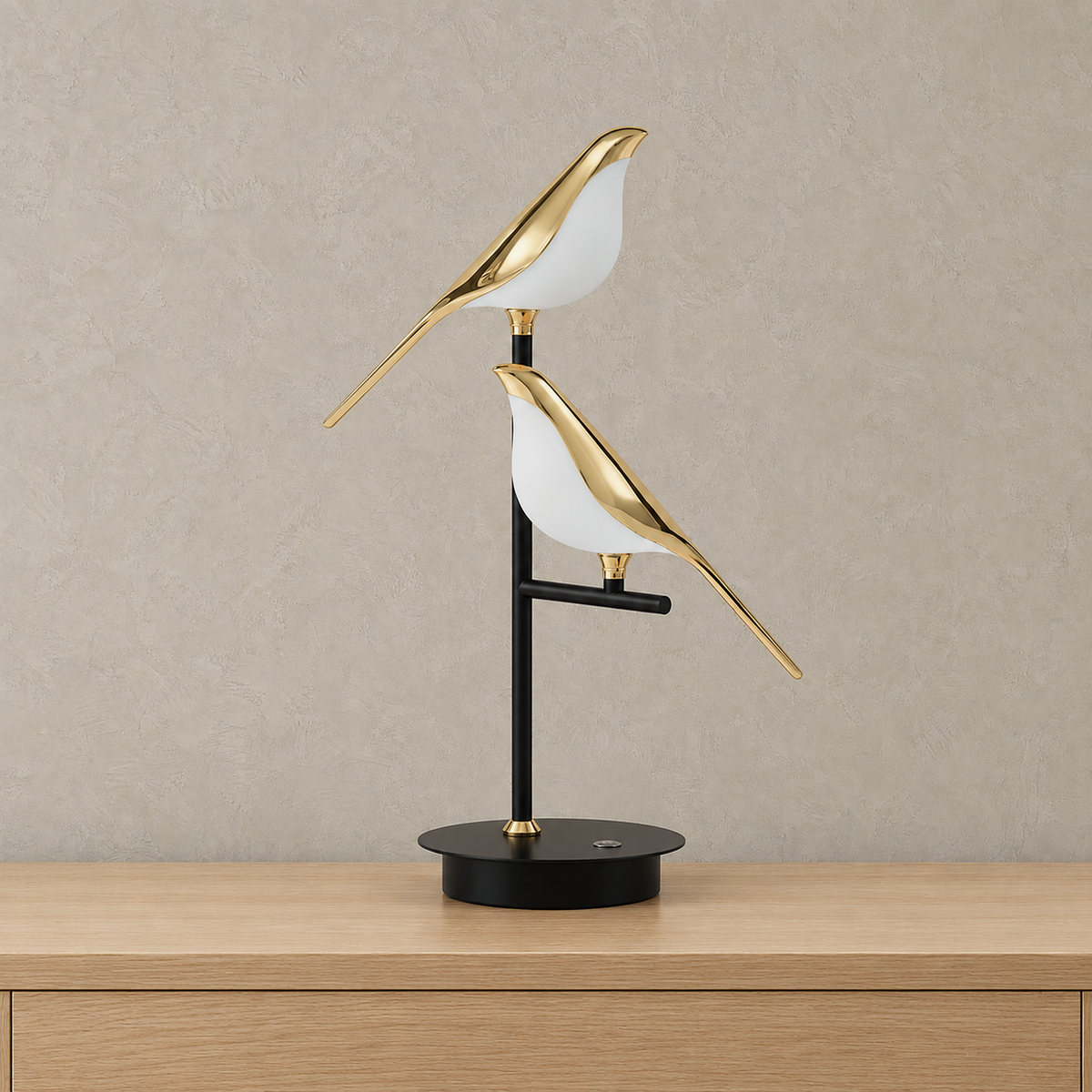 Nirelta black and gold bird table lamp with two unlit white and gold birds on a round black base