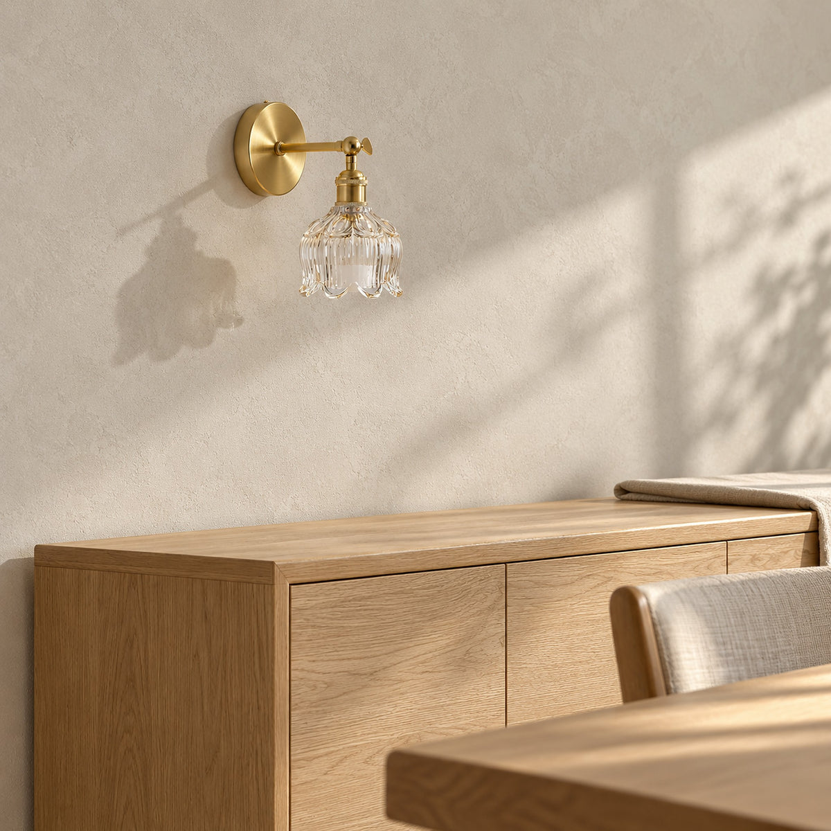 Nolavire golden cordless wall lamp switched off on a sunlit dining room wall with a clear glass shade