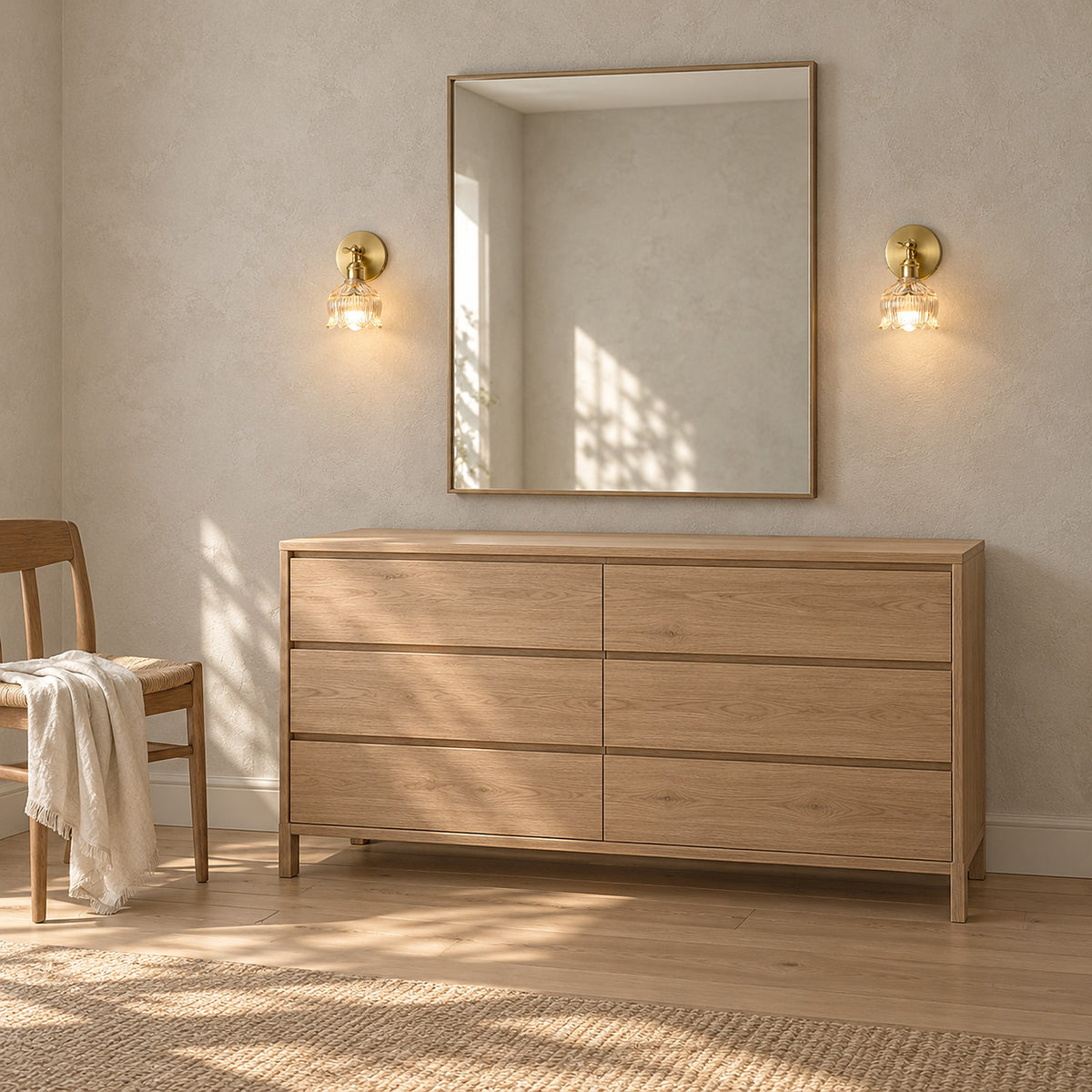 Nolavire brass coloured wall light pair glowing beside a mirror above a wooden dresser.