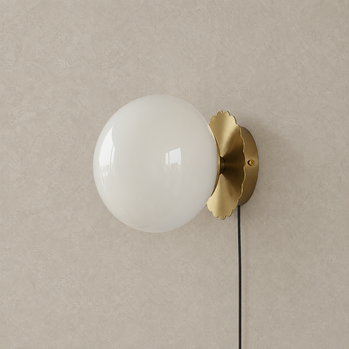 Novirela gold and white plug in wall sconce with a frosted glass globe unlit on a plain backdrop