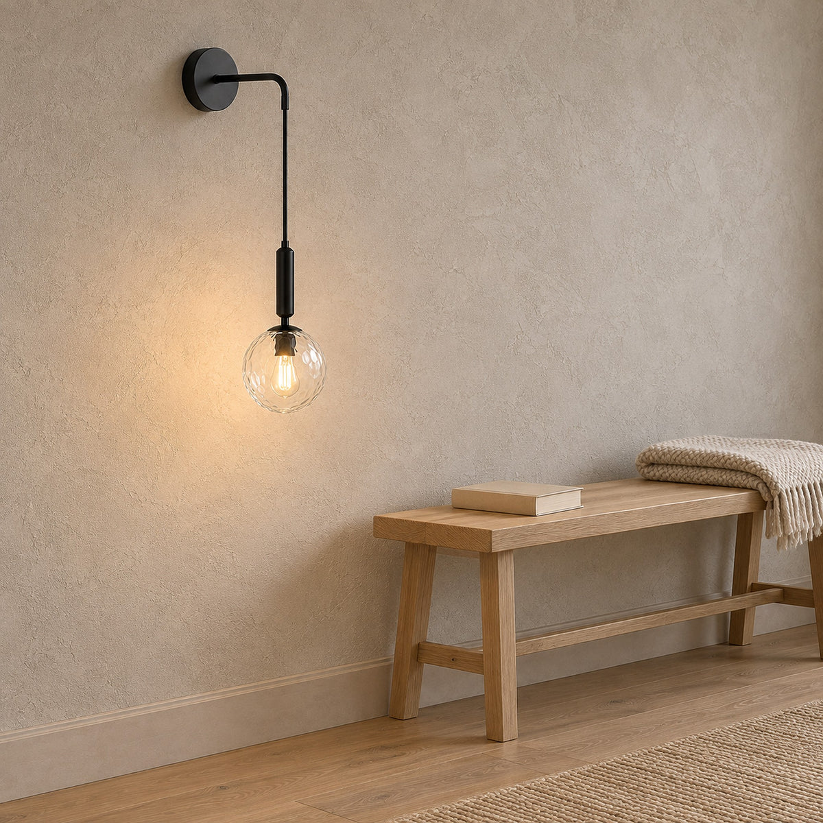 Orlamen black hardwired wall light glowing above a landing, the plaster below left clear and unbroken