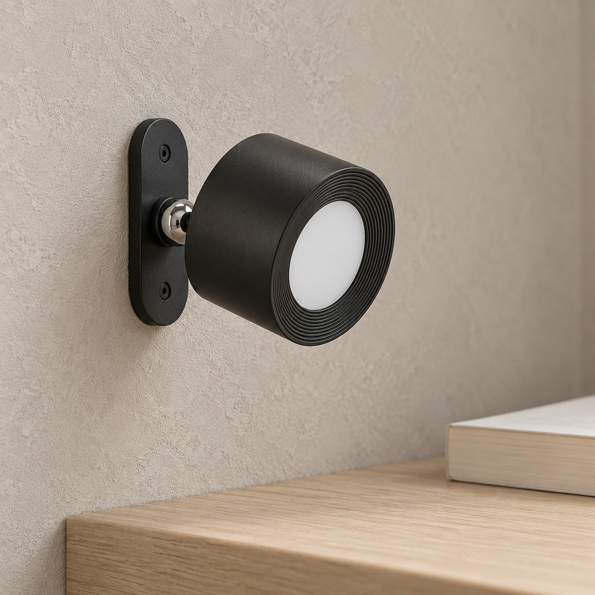 Orsilen black wireless wall light, close view of the spotlight head and magnetic joint