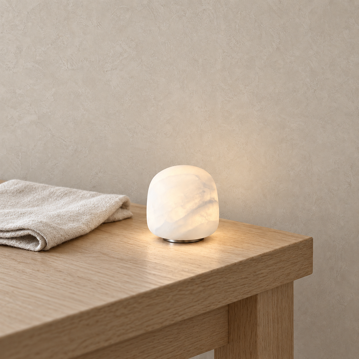 Ravelmo white table lamp glowing with soft neutral light on the corner of a kitchen breakfast table