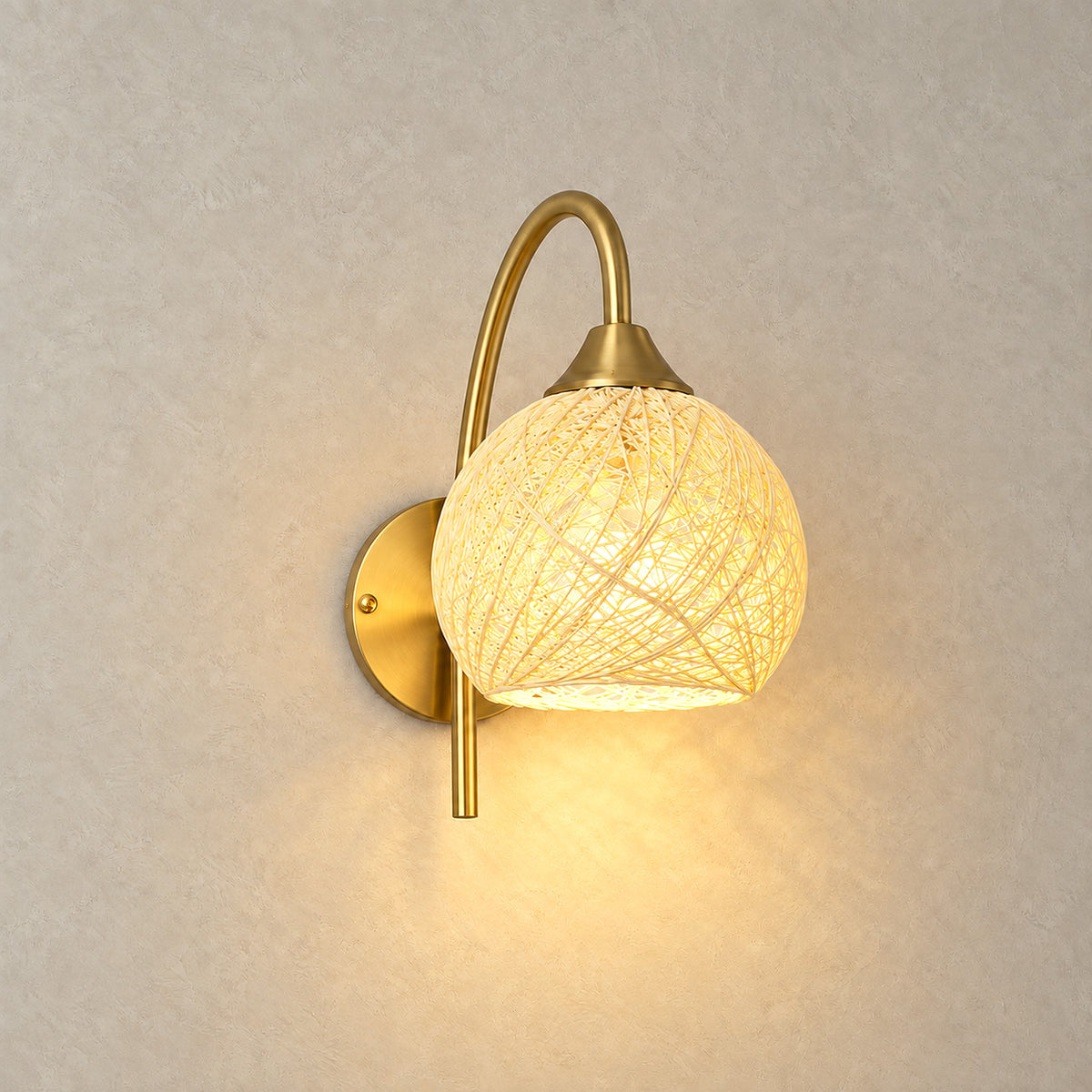 Remilvo gold rechargeable wall sconce lit with a soft glow through its fabric shade on greige plaster