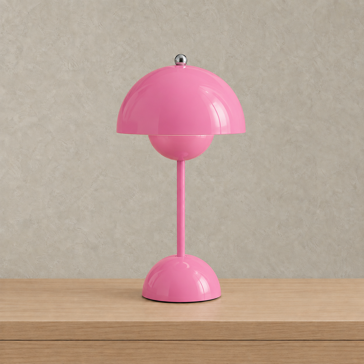 Retomira pink battery operated table lamp unlit against warm greige plaster #color_pink