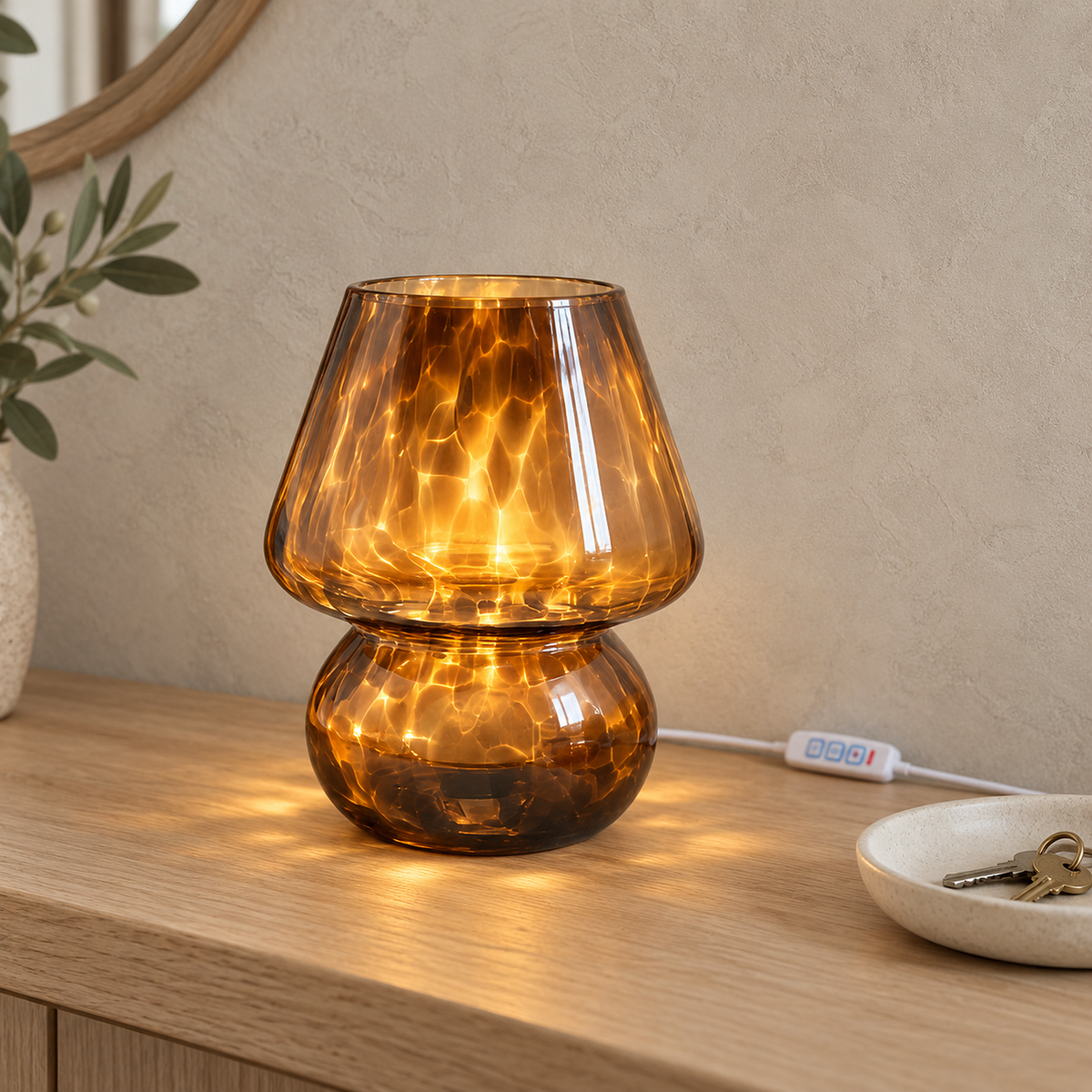 Rimelota brown table lamp glowing on an entryway console in daylight, its speckled glass shade lit