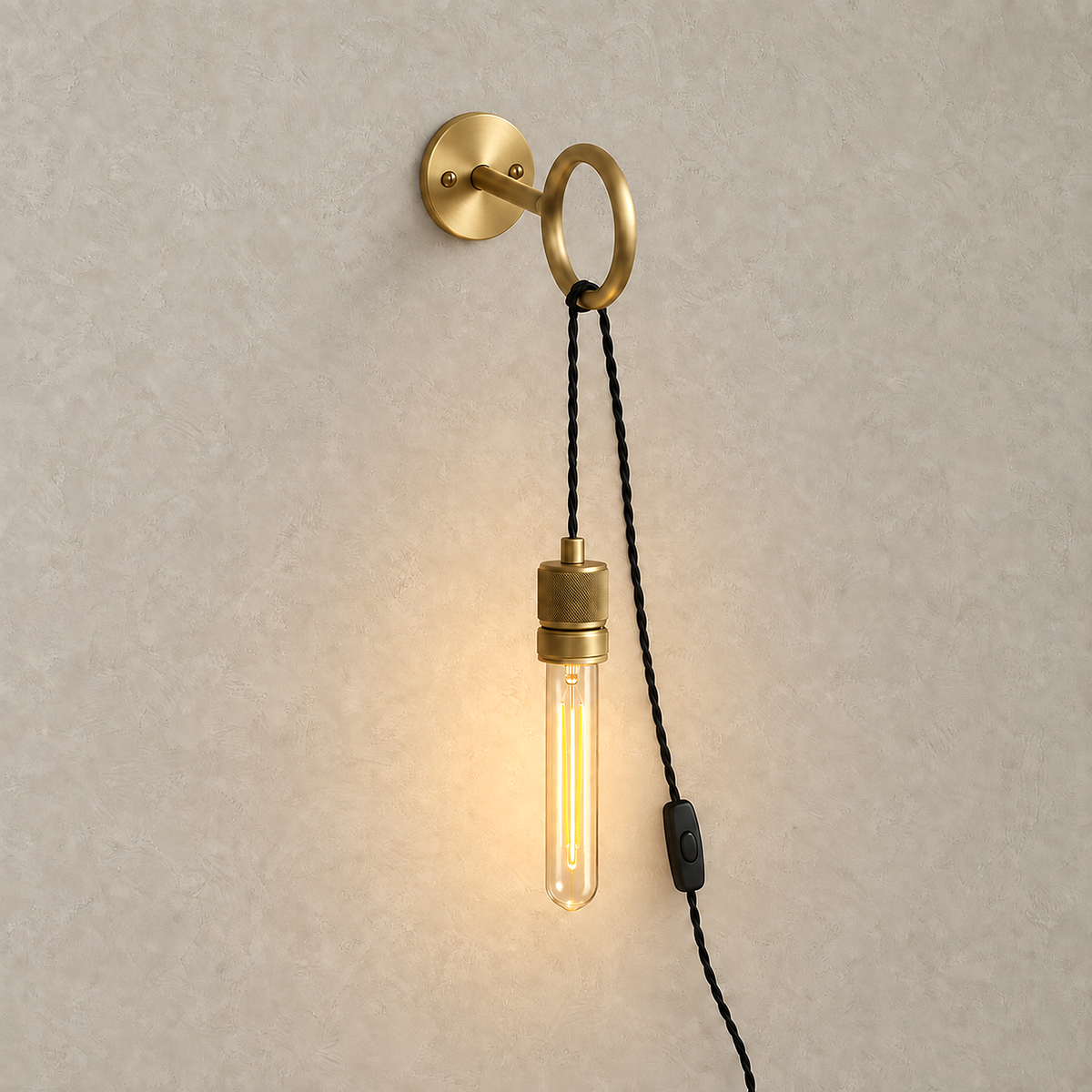 Rovenila gold bedside wall light lit with its exposed bulb in a shadeless metal body