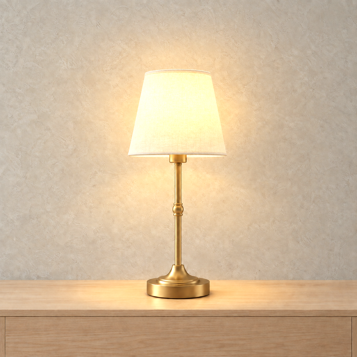 Sanovire gold and white bedside lamp glowing through its white fabric shade