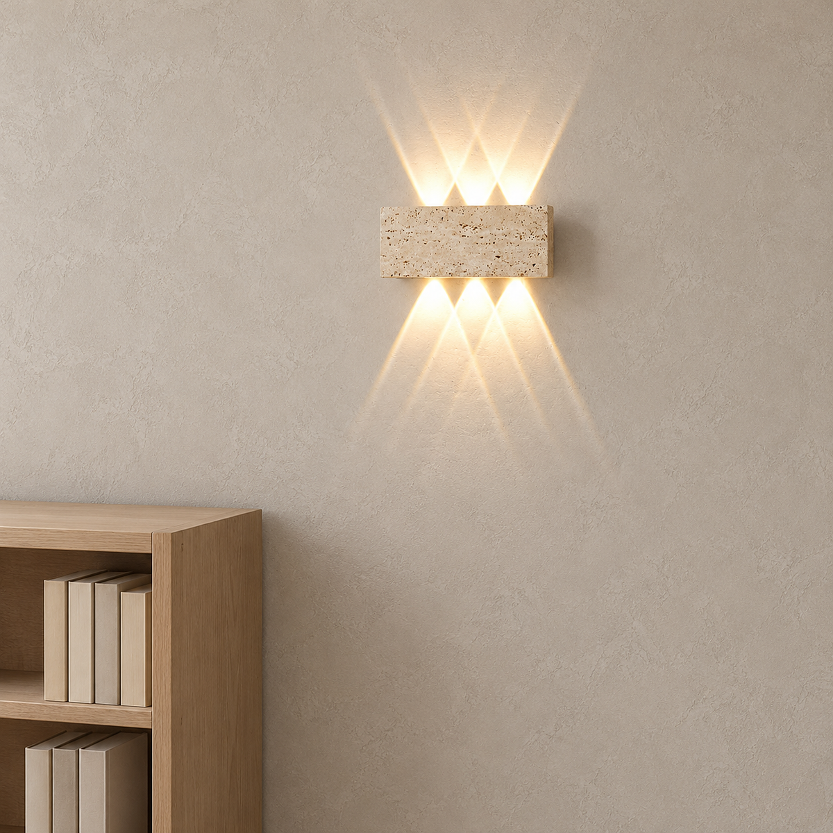 Sarivol beige stone wall lamp lit beside tall bookshelves in a daylit library nook