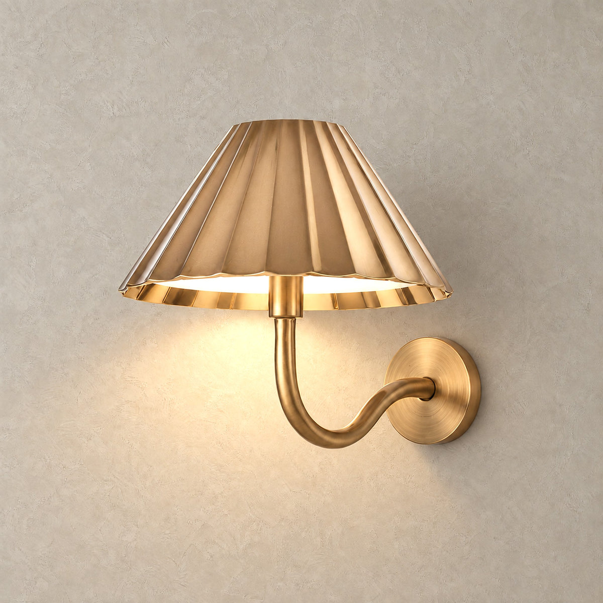 Selorna gold cordless wall lamp switched on against greige plaster