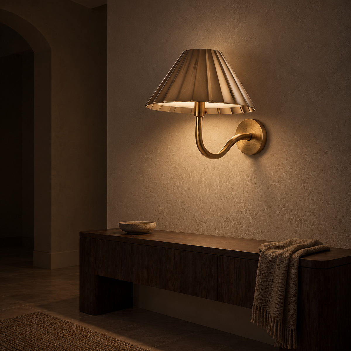 Selorna gold LED wall sconce dimmed to a softer evening glow in an entryway