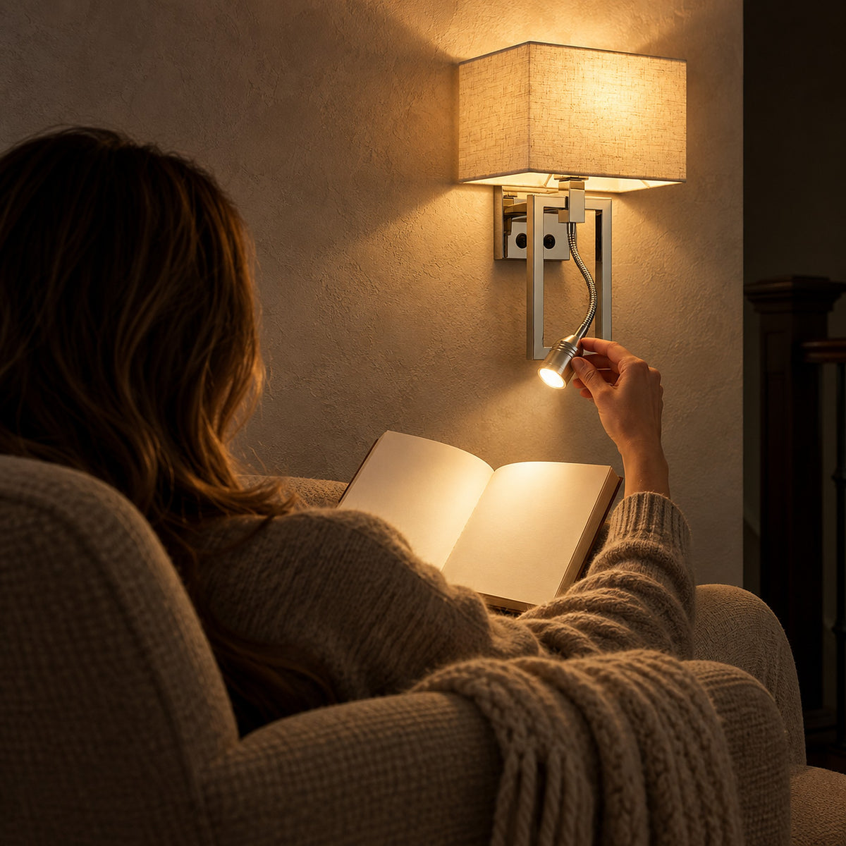 Silarno chrome wall light with gooseneck reading lamp aimed at a book in an armchair on an upstairs landing
