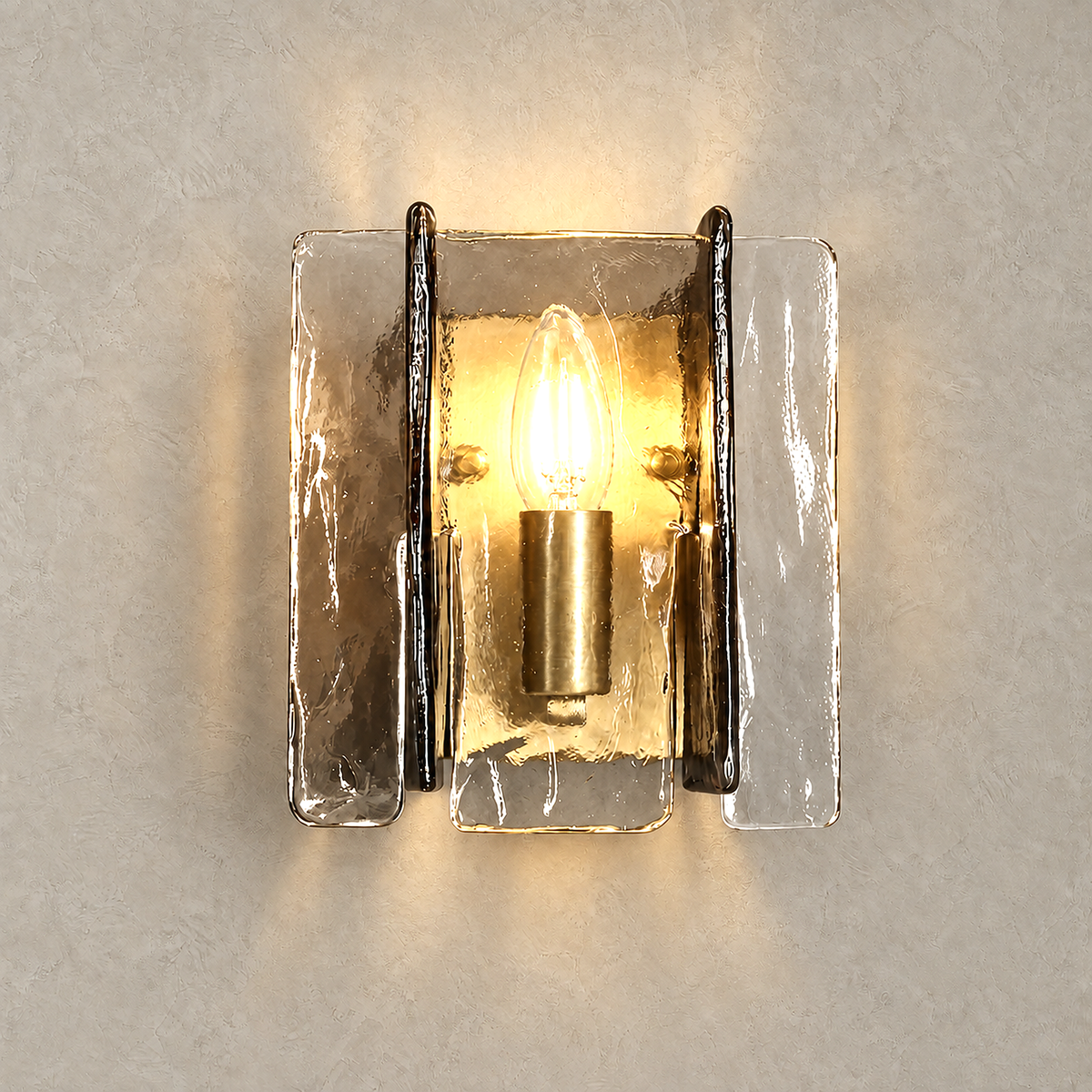 Simaelo black glass wall sconce lit with warm light against greige plaster