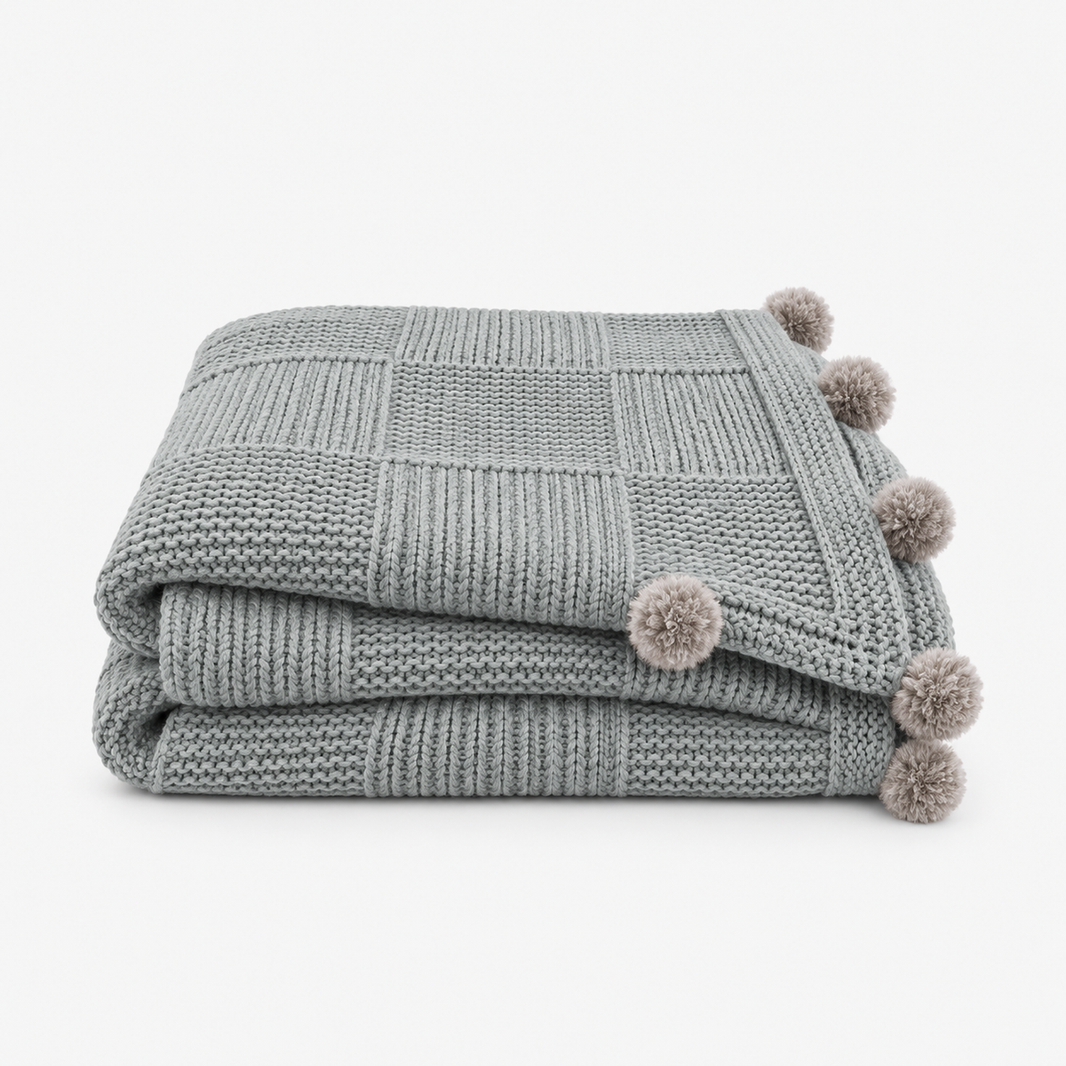 Talenvo knit throw blanket in light gray, loosely folded with fuzzy pom poms along the edges