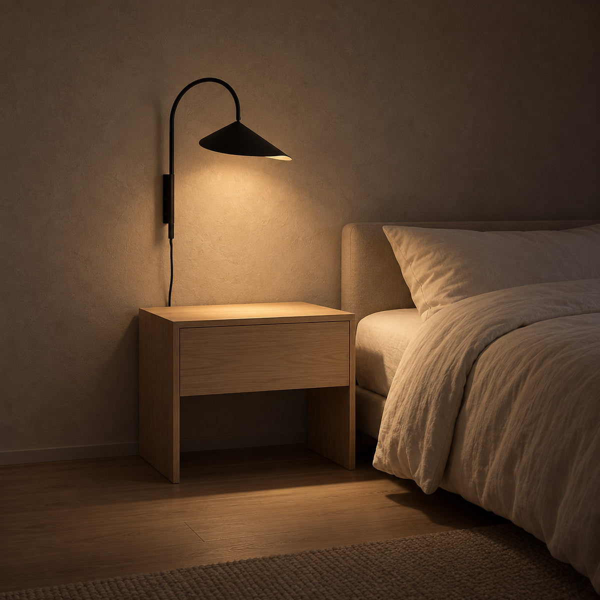 Talirsa black bedside wall light above a bare nightstand in a bedroom at night