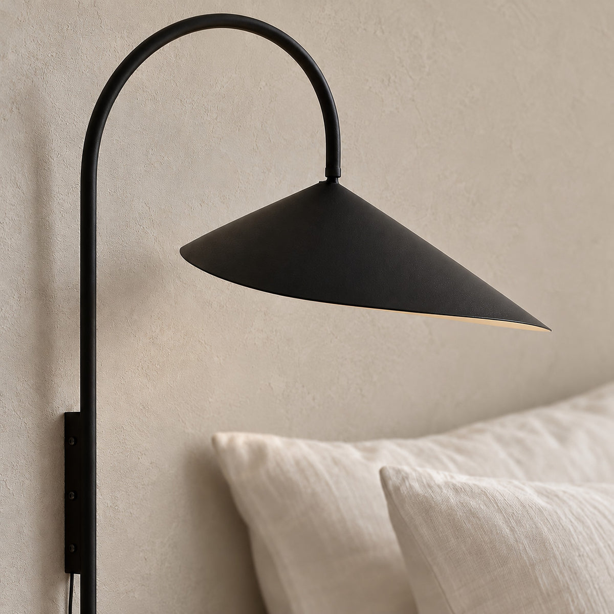 Talirsa black wall sconce in close detail, showing the shade edge and curved stem