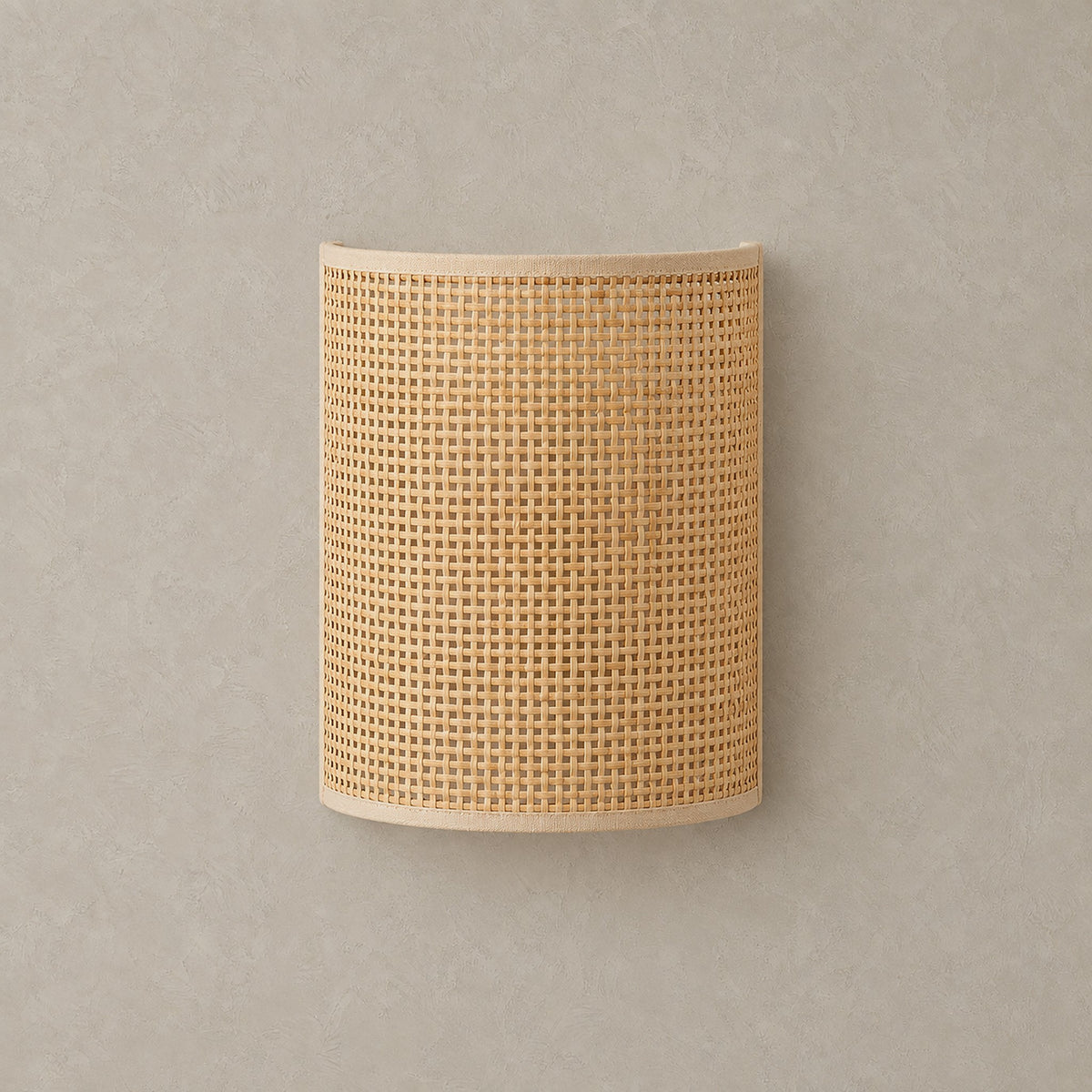 Talmevi light tan plug in wall sconce with a woven bamboo and rattan shade, unlit against greige plaster