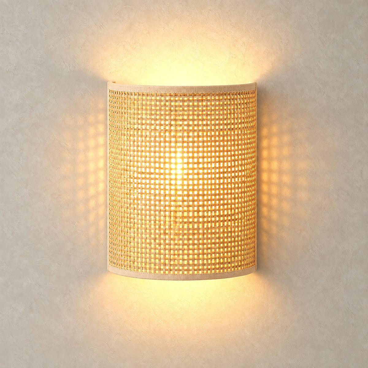 Talmevi light tan wall sconce glowing through its open bamboo and rattan weave