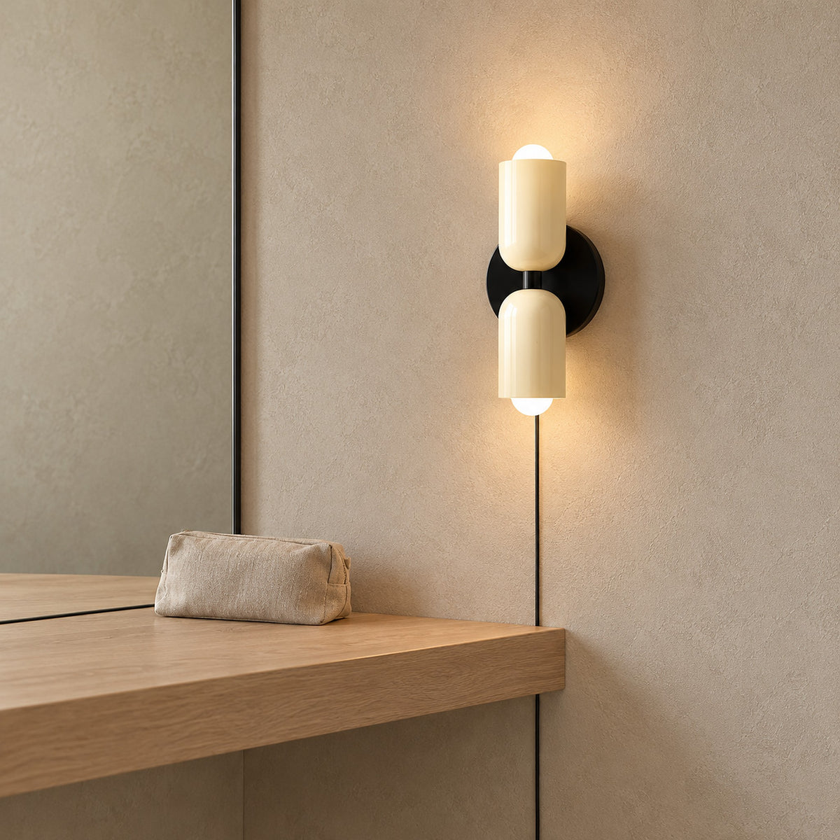 Talomi beige bedside wall light in profile beside a dressing room mirror, both heads glowing