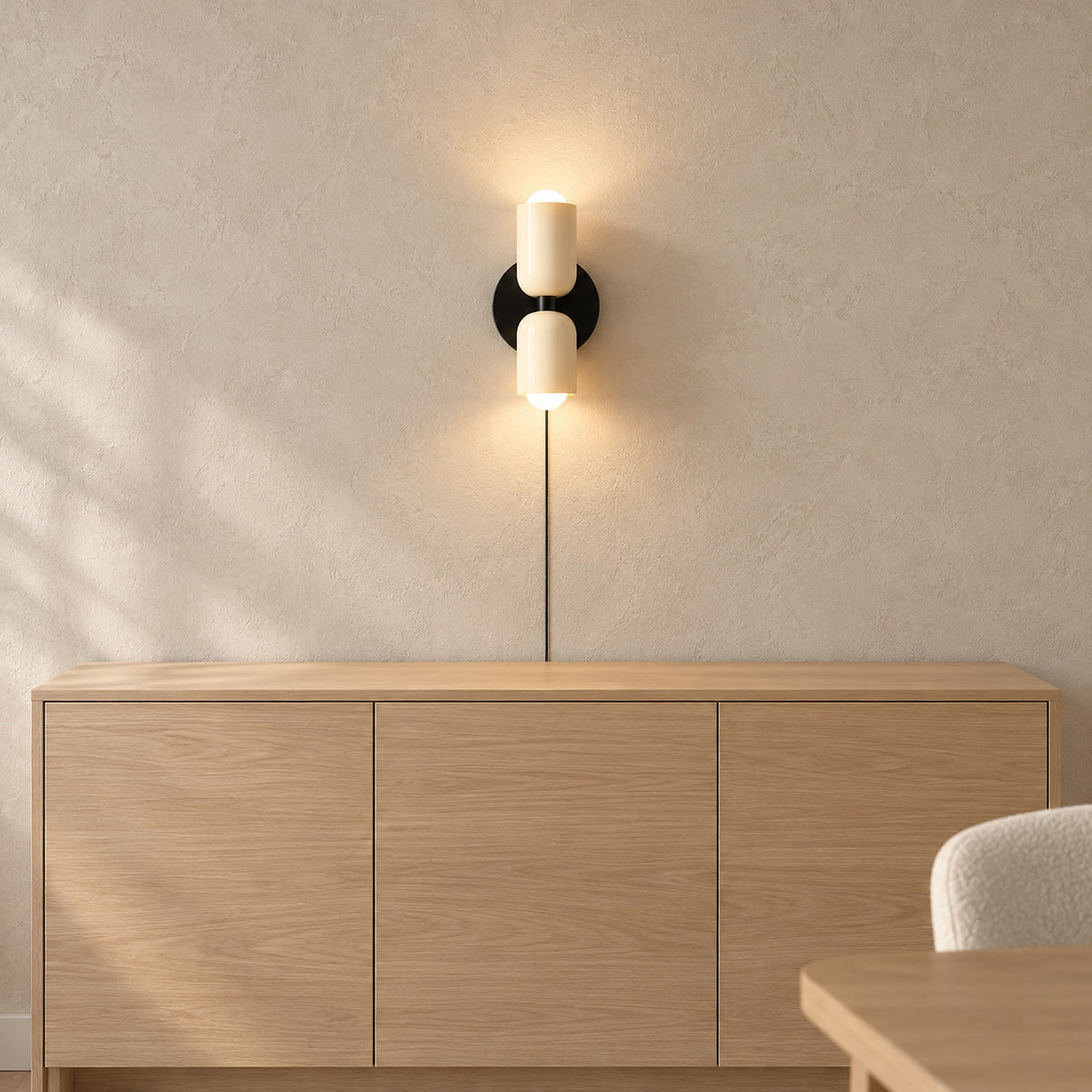 Talomi beige wall light brightening the dining room above a bare pale sideboard