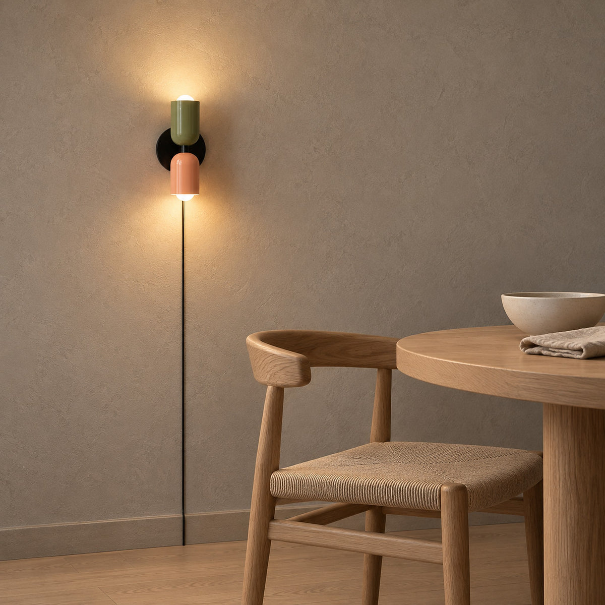 Talomi green and pink wall light glowing in a pale dining corner in late afternoon #color_green & pink