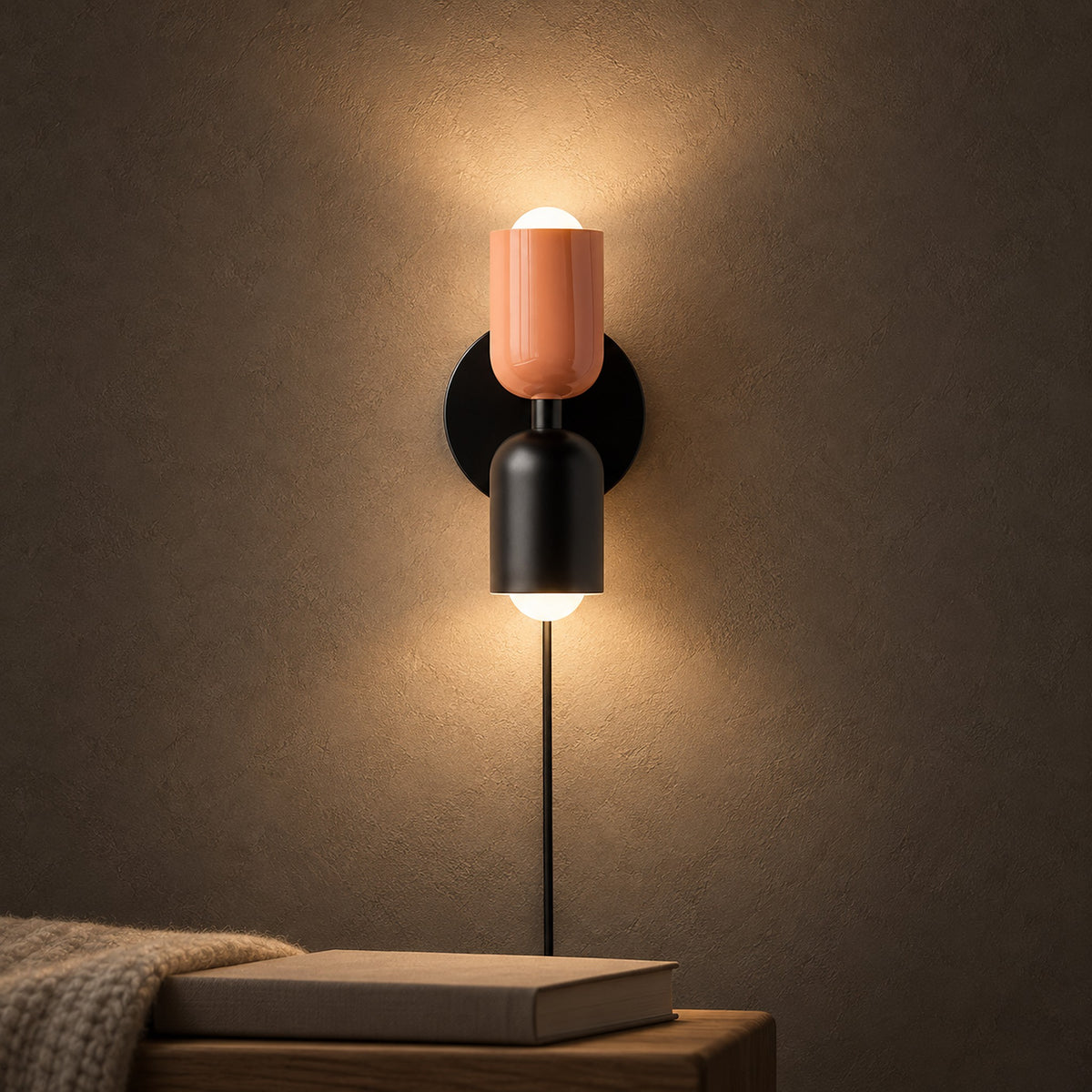 Talomi pink and black wall light casting a warm hallway glow beside a resting hand #color_pink & black
