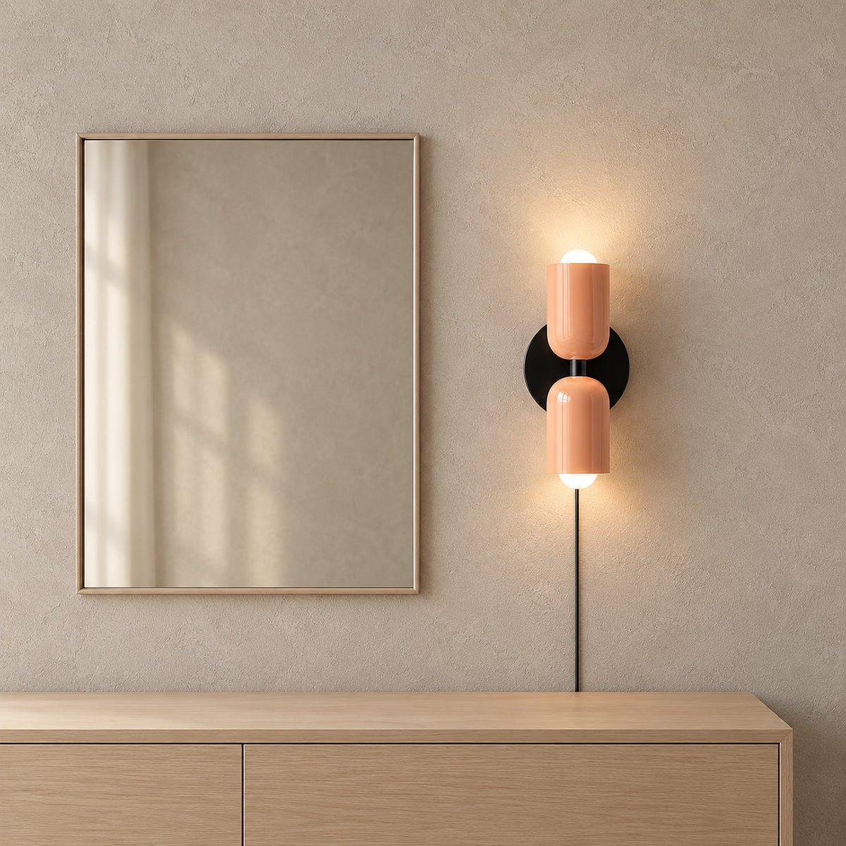 Talomi pink bedside wall light glowing beside a bedroom dressing mirror with its black cord visible #color_pink
