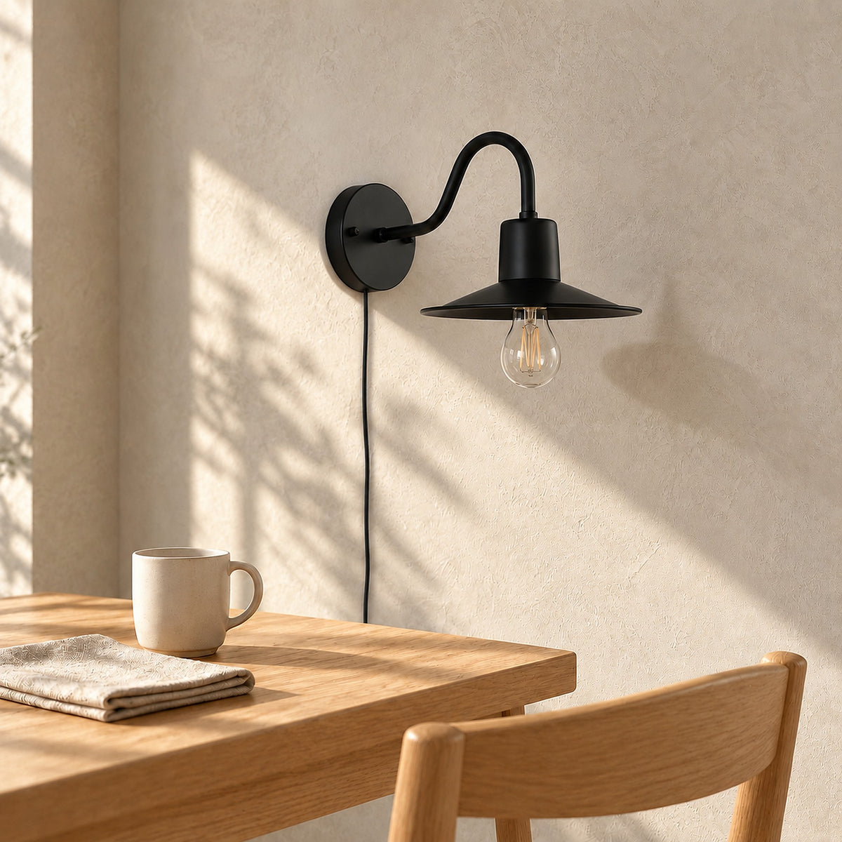 Tarelio black plug in wall sconce unlit on the wall above a breakfast table by day