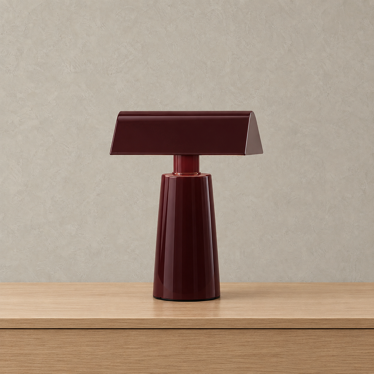 Ternilo red rechargeable table lamp unlit against a plain plaster wall, showing its shade and rounded base