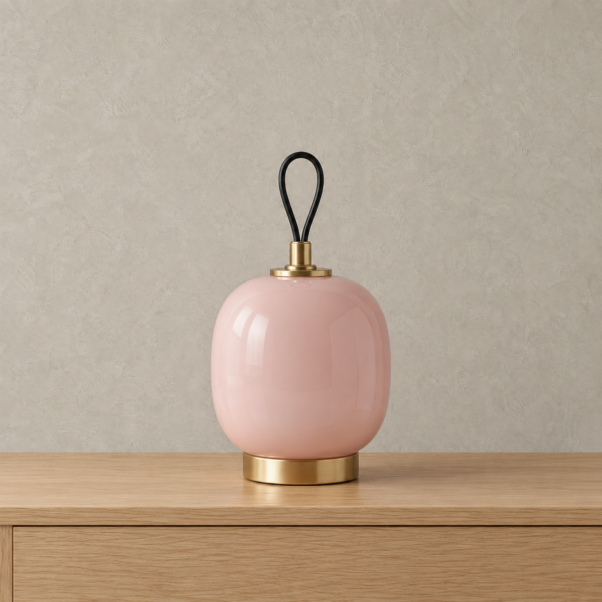 Timarelo cream pink rechargeable table lamp shown unlit, glass body above a circular gold tone base
