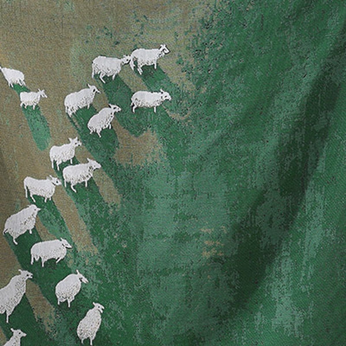 Close up of the Timarno woven sheep throw blanket showing white sheep on green fabric with soft folds.