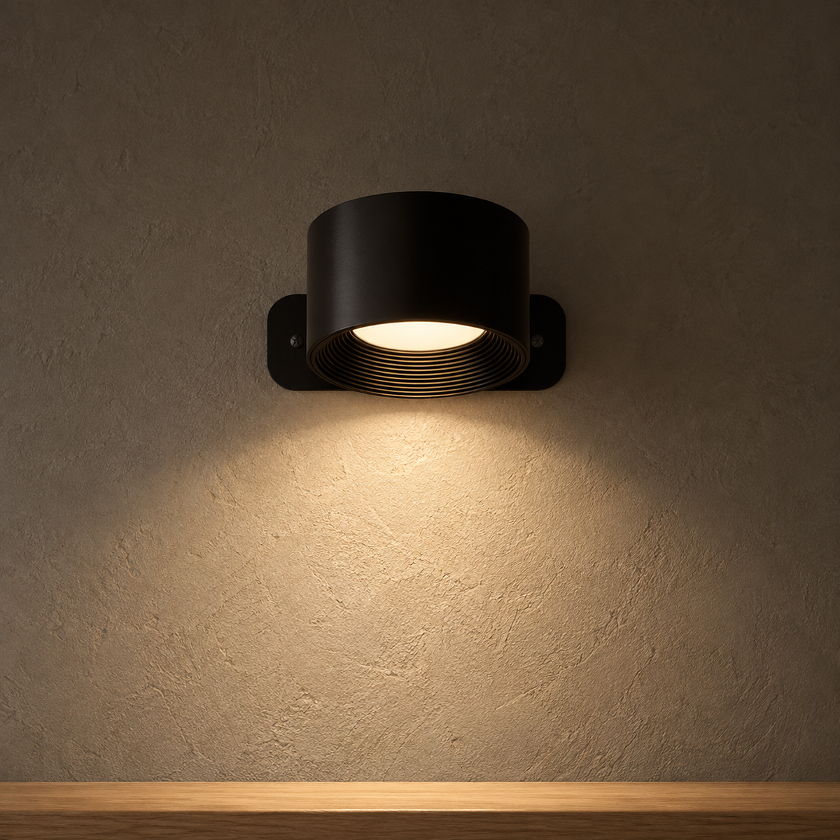 Tomelira black battery operated wall sconce casting one downward warm pool on a living room wall at night