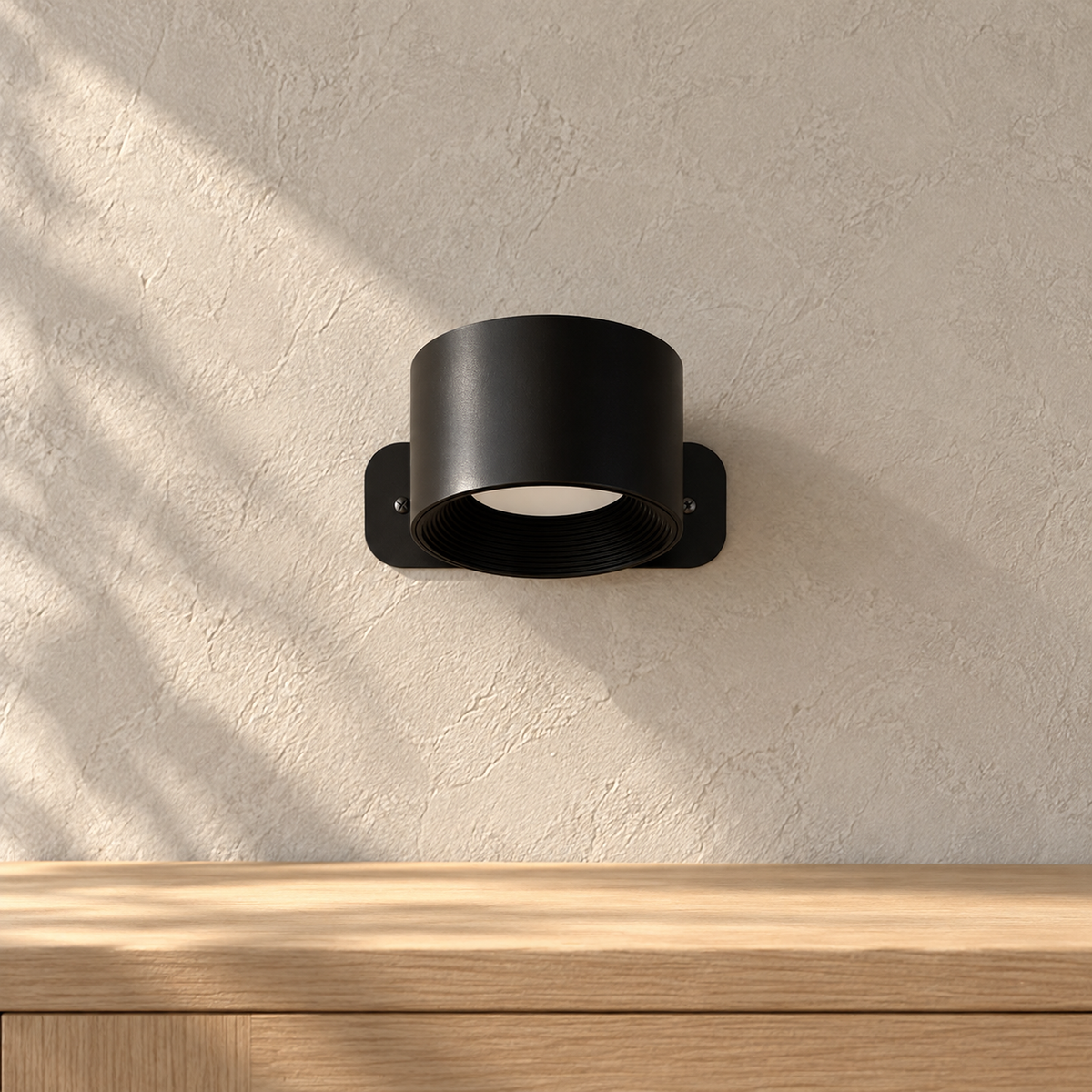Tomelira black wireless wall light switched off in direct sunlight above a dining console edge