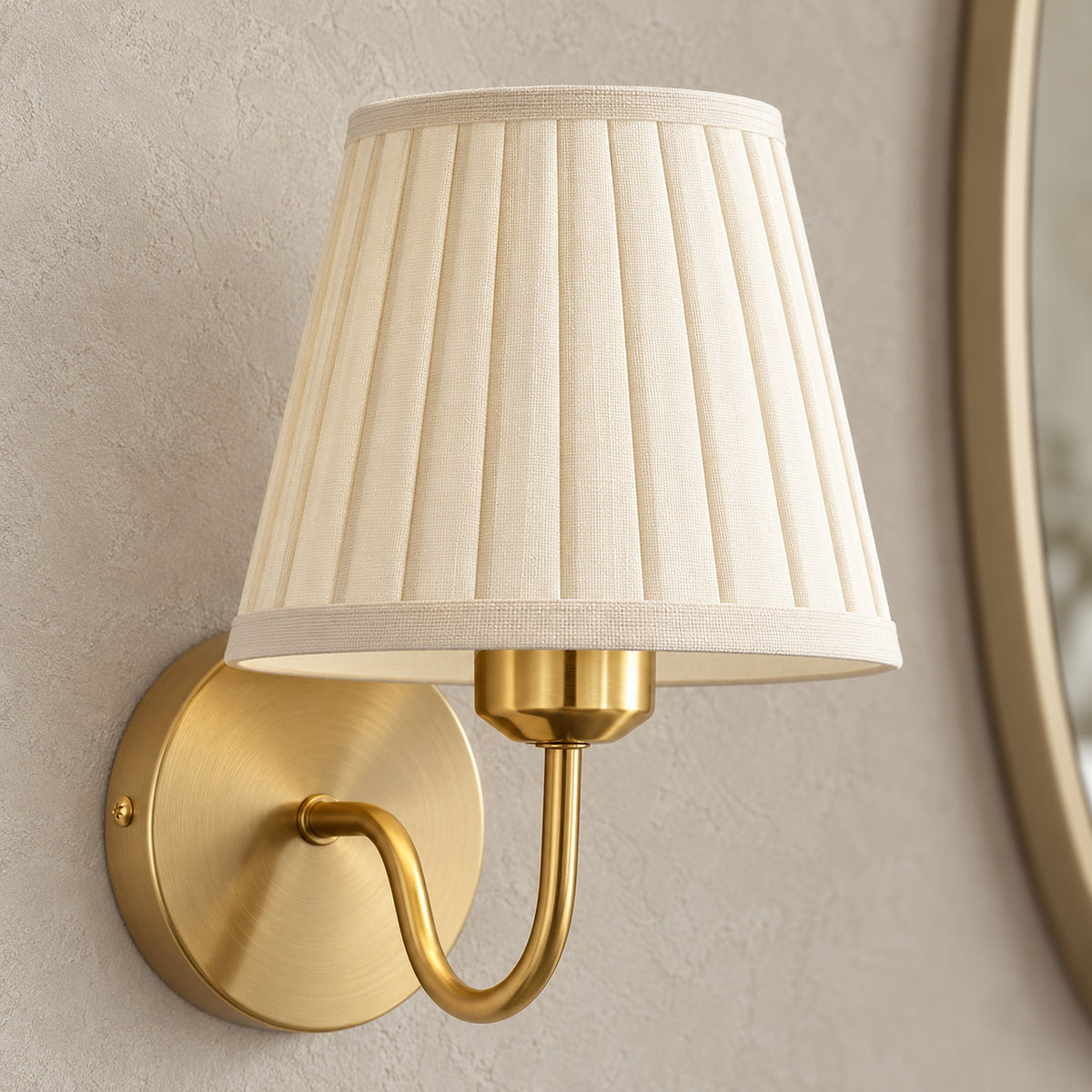 Tomirel gold wall lamp, close up of the pleated fabric shade, unlit in a daylit dressing room