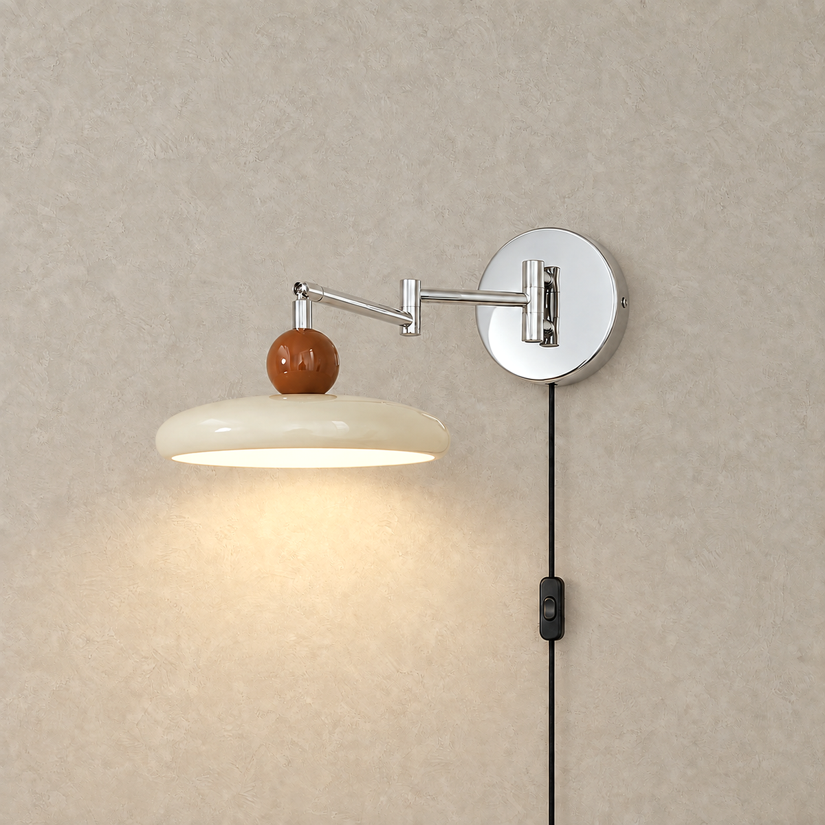 Tovessi beige swing arm wall lamp switched on with warm downward light on a plain plate