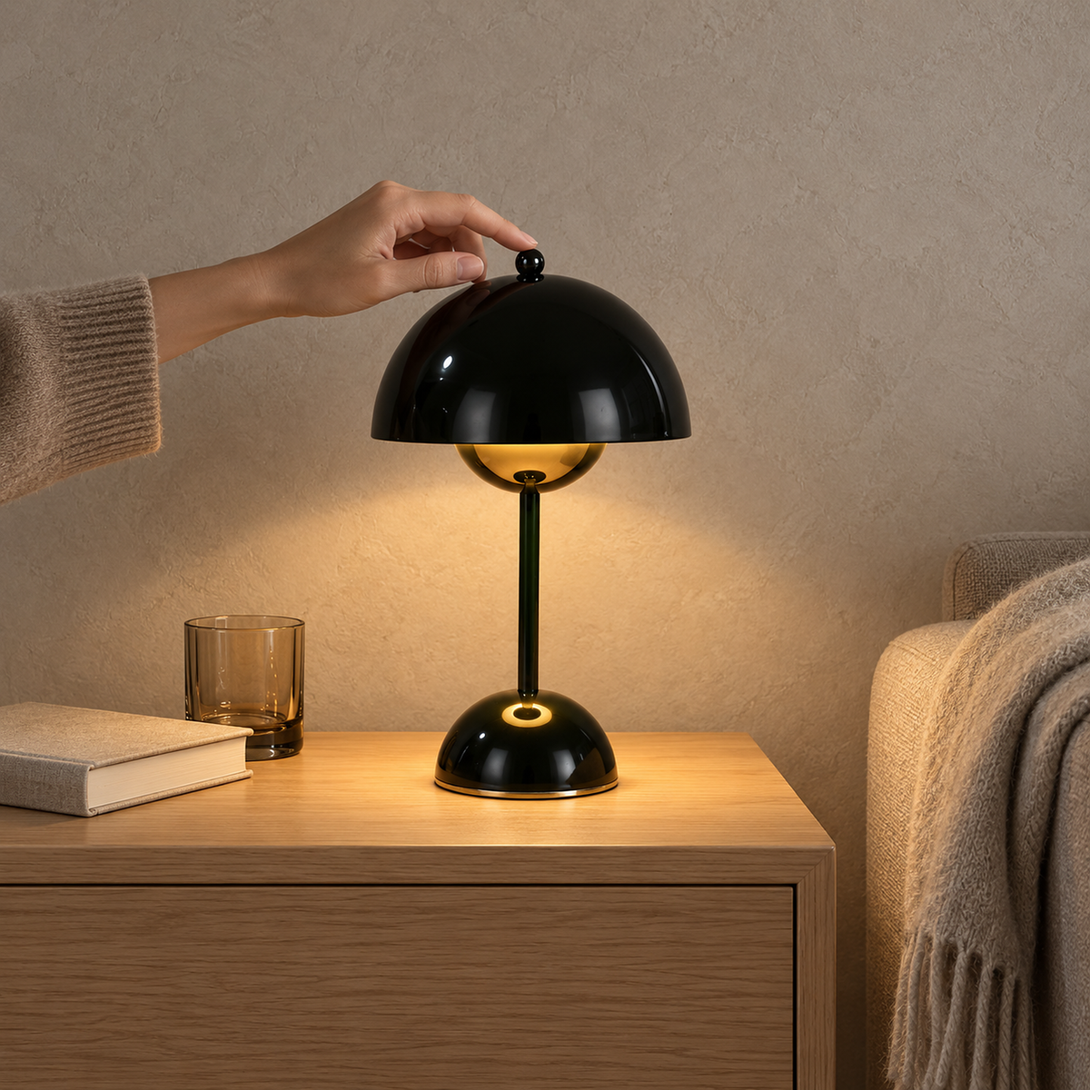 Varimel black portable table lamp glowing beside an oatmeal sofa in a living room