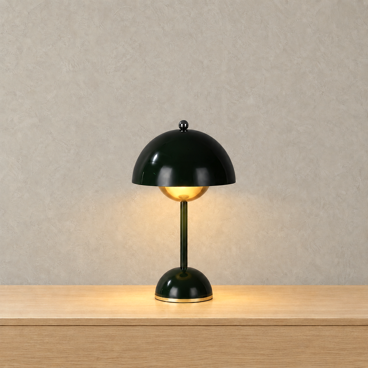 Varimel black portable table lamp switched on and casting a warm glow across a tabletop