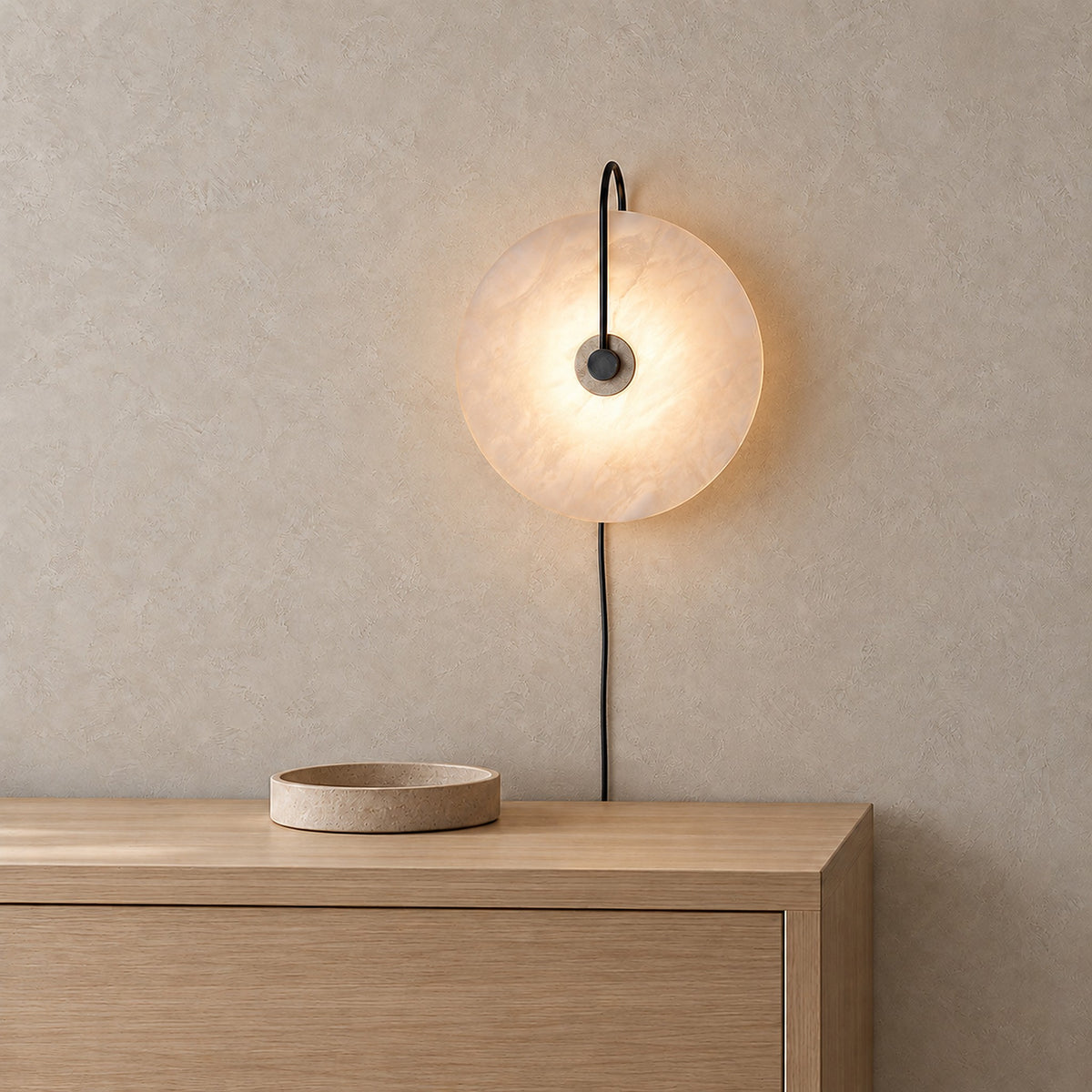 Velirsa black plug in wall sconce with luminous veining around the central metal fitting