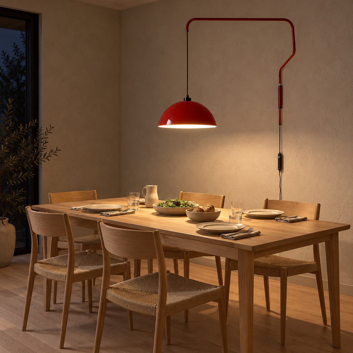 Velisano dark red wall sconce hanging above a set dining table in a dining room