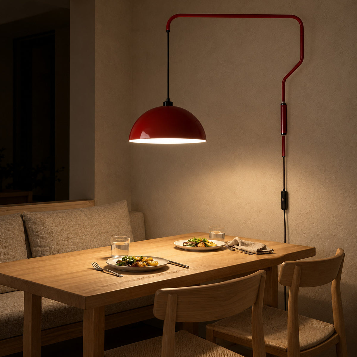 Velisano dark red wall sconce with a dome shade casting light onto supper in a breakfast nook